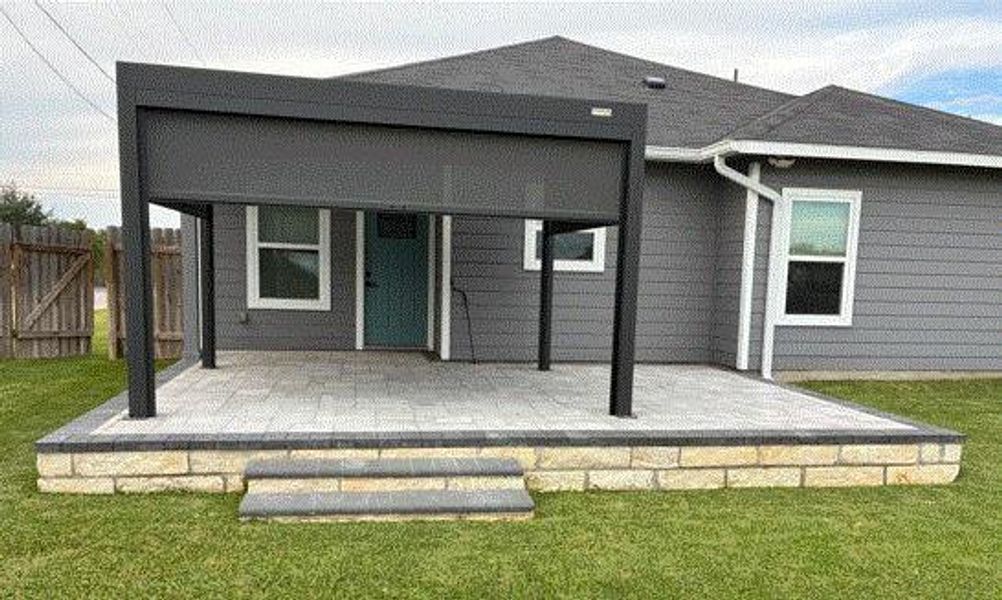 Rear view of house with a deck and a lawn