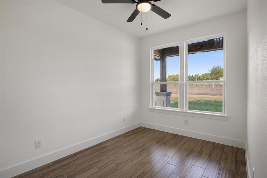 Unfurnished room featuring ceiling fan and hardwood / wood-style floors