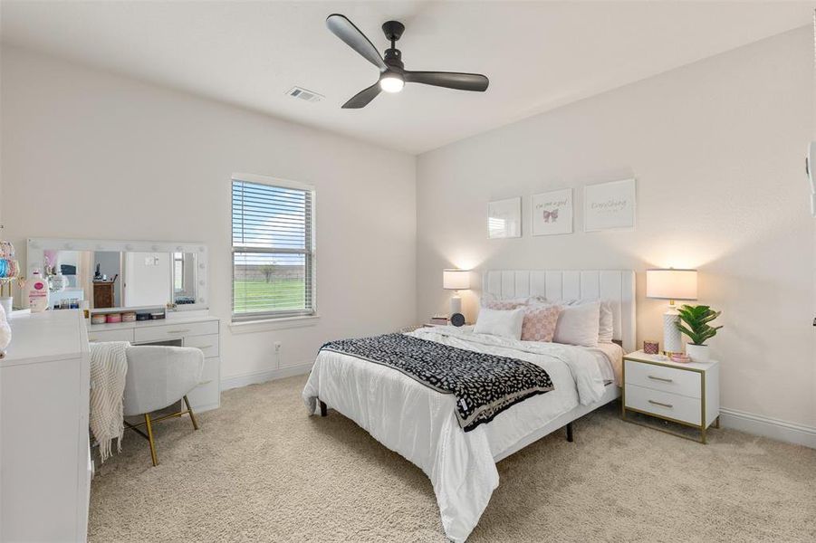 Bedroom with light carpet, baseboards, visible vents, and a ceiling fan
