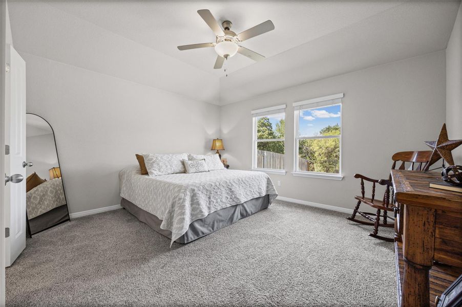 High vaulted ceilings and plush carpeting define this relaxing main-level bedroom retreat.
