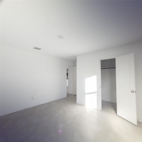 Unfurnished bedroom featuring a closet and light tile patterned floors