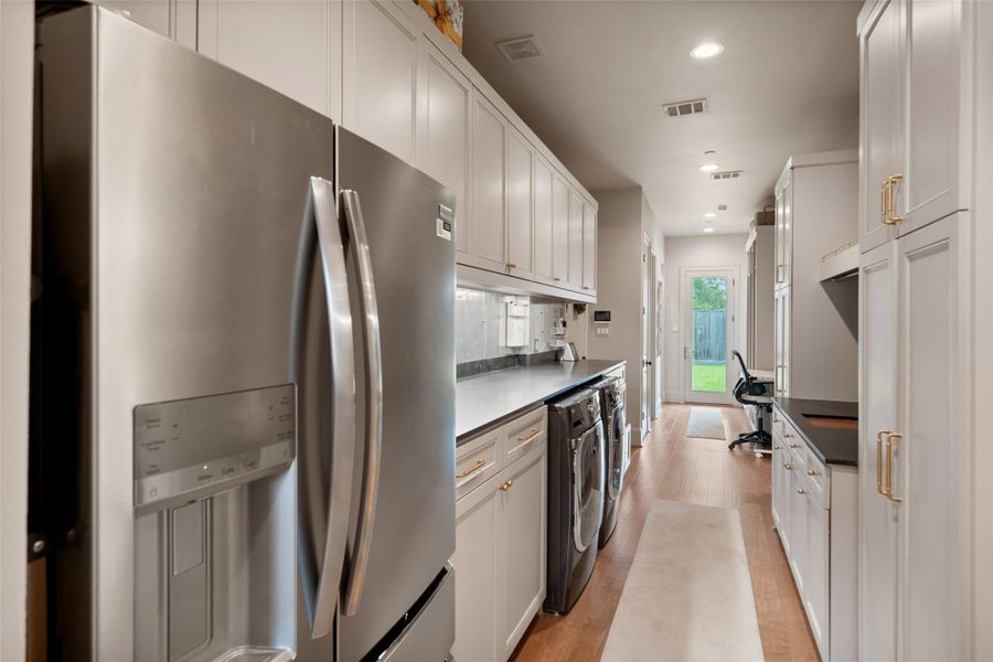 This additional view of the multi-functional mudroom highlights a built-in desk area, perfect for managing household tasks or working from home. Alongside the lockers and washer and dryer, it offers a versatile, organized space for busy daily life.