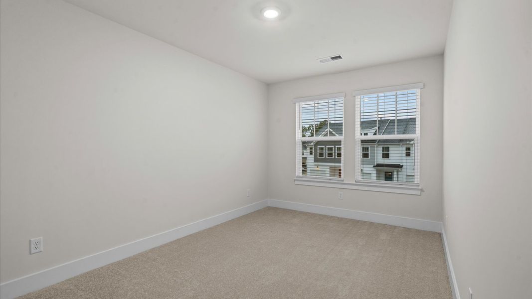 Notable secondary bedroom offering cozy carpeted flooring and a stylish walk-in closet
