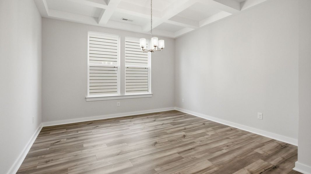 Dining Room with two windows, chandelier, coffered ceiling trim, and hard surface flooring Dining Room with two windows, chandelier, coffered ceiling trim, and hard surface flooring