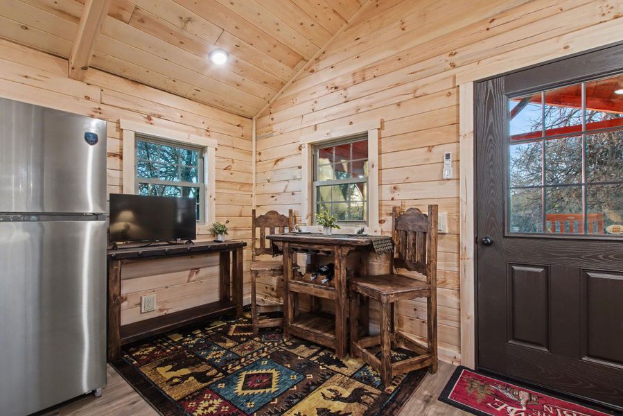 Dining area featuring vaulted ceiling, wood finished floors, wooden walls, recessed lighting, and wooden ceiling