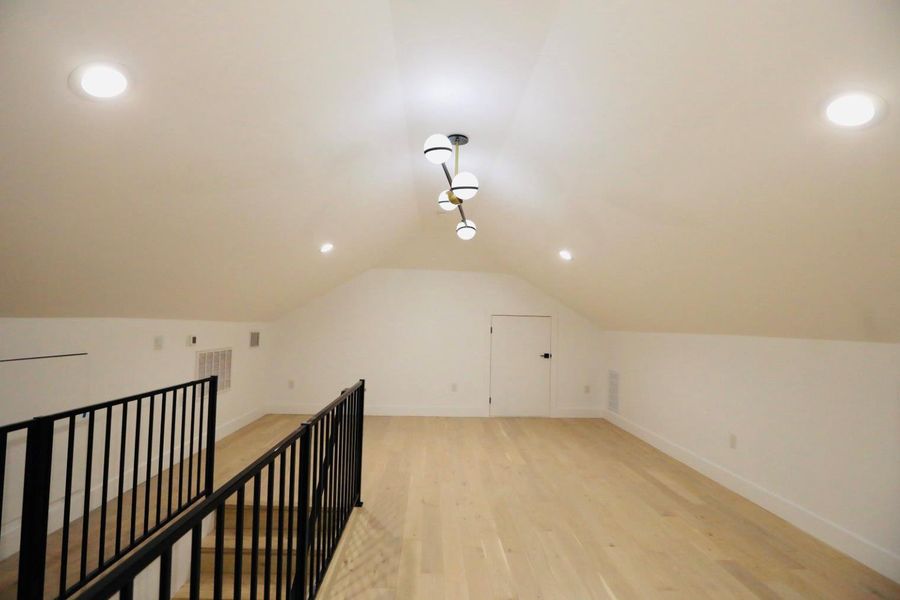 Additional living space with light wood-type flooring, recessed lighting, and vaulted ceiling