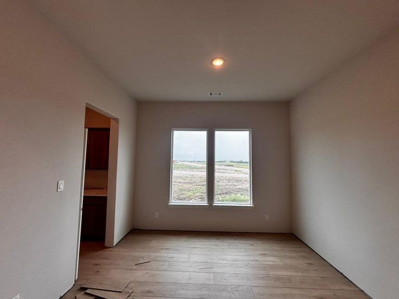 Room with wood-finish flooring, recessed lighting, and a dual-pane window