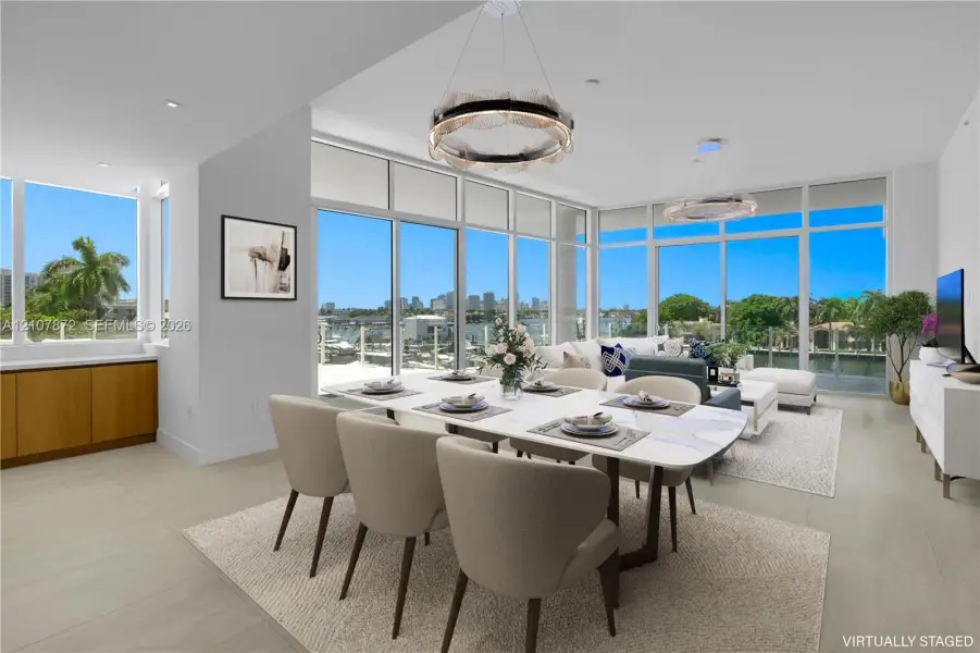 Open-concept living space featuring floor-to-ceiling windows, porcelain tile flooring, built-in lower cabinetry with wood finish, and recessed lighting Open-concept living space featuring floor-to-ceiling windows, porcelain tile flooring, built-in lower cabinetry with wood finish, and recessed lighting