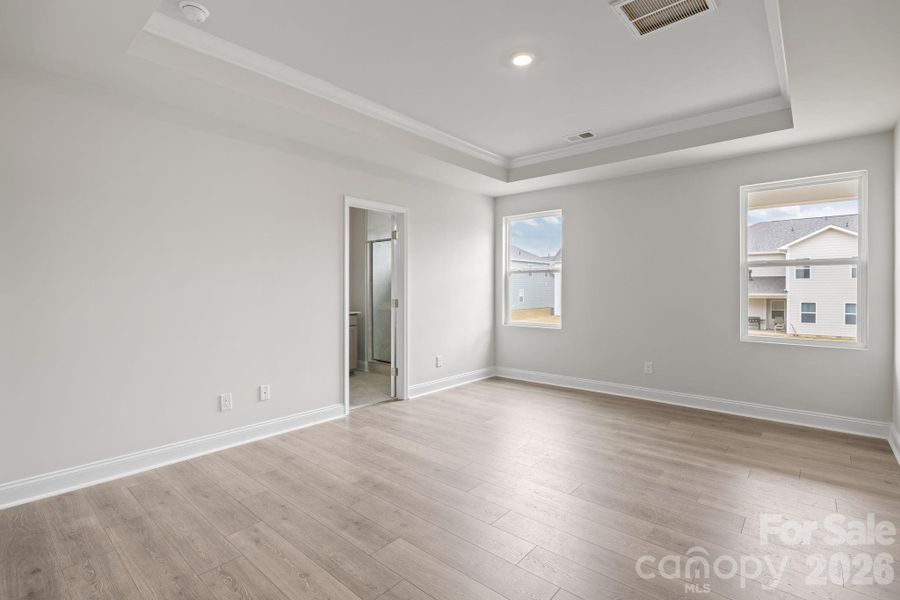 Primary on the Main with laminate flooring and a Tray ceiling Primary on the Main with laminate flooring and a Tray ceiling
