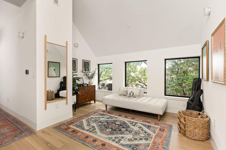 Hardwood flooring extends through this naturally illuminated space with large windows overlooking verdant trees. Hardwood flooring extends through this naturally illuminated space with large windows overlooking verdant trees.
