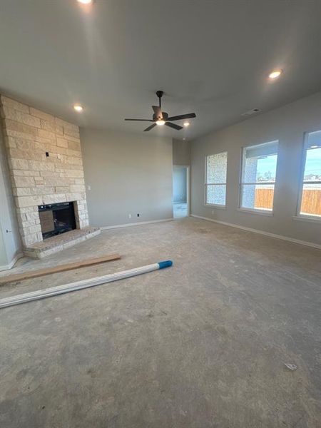 Unfurnished living room featuring a fireplace and ceiling fan