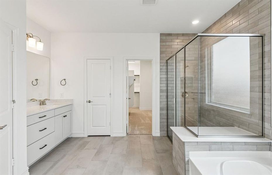 Luxurious owner's bath complete with double sinks and a generous shower  *Real home pictured