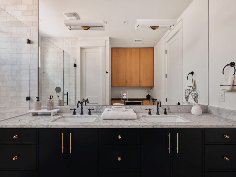 Full bath with double vanity and a stall shower