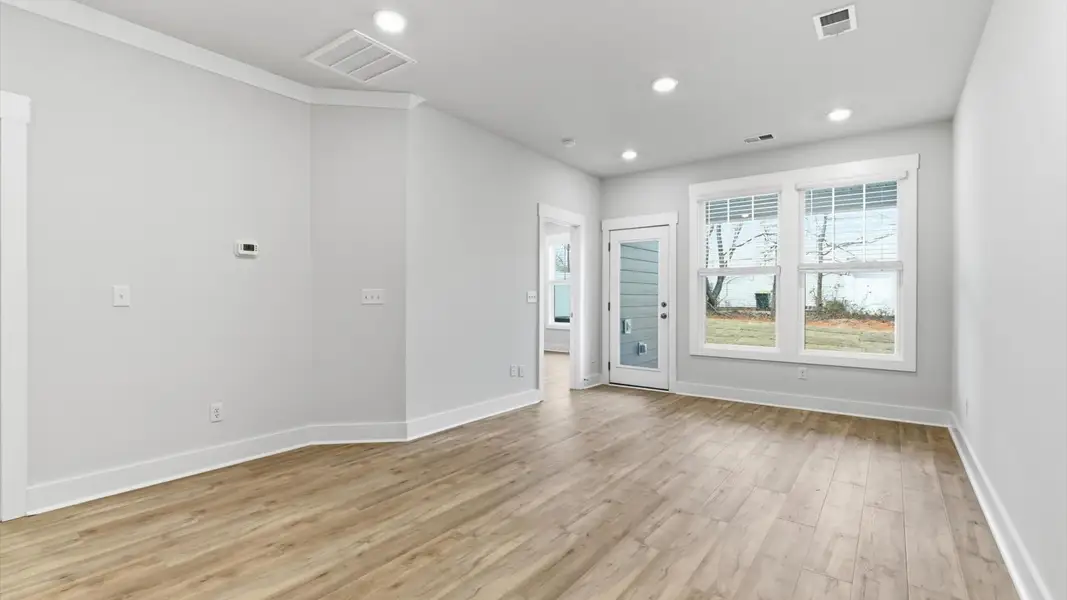 Spacious family room with rich hardwood flooring and elegant trim work in a reputable DRB Homes build at Pelham Crossing