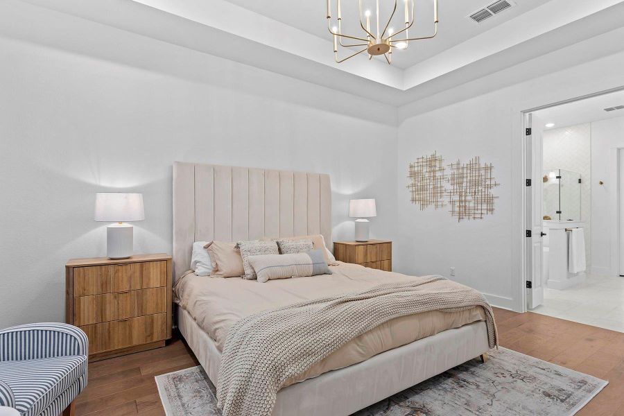 Bedroom with dark hardwood / wood-style floors, connected bathroom, and a notable chandelier