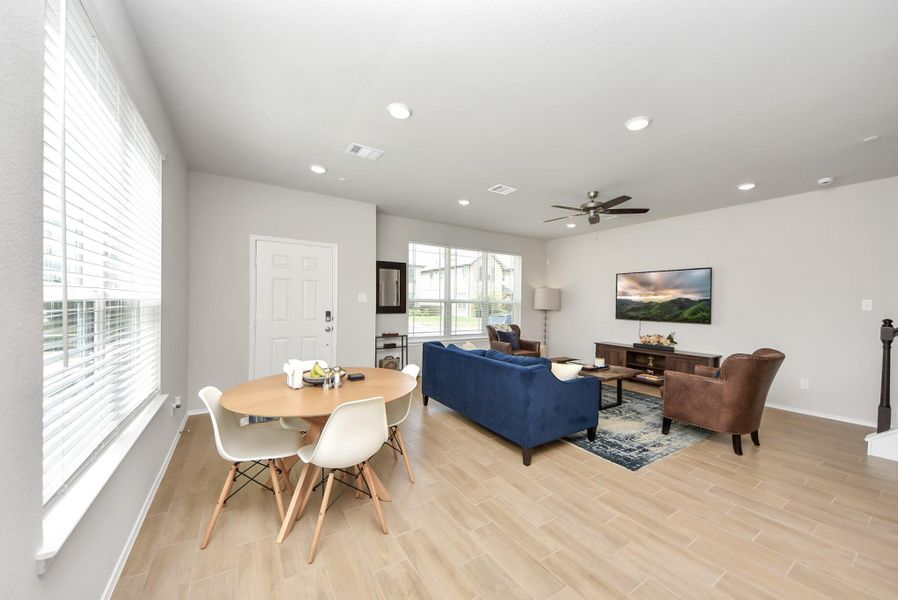 View the dining and living combination room as seen from the breakfast bar area in the kitchen. Note pretty hard surface flooring & ceiling fan. Lots of windows bring in great light to this space. View the dining and living combination room as seen from the breakfast bar area in the kitchen. Note pretty hard surface flooring & ceiling fan. Lots of windows bring in great light to this space.