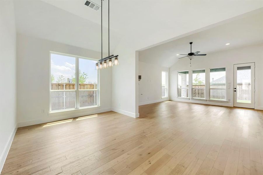 Spacious open-concept interior featuring light wood-finish flooring, vaulted ceilings, and extensive window light Spacious open-concept interior featuring light wood-finish flooring, vaulted ceilings, and extensive window light