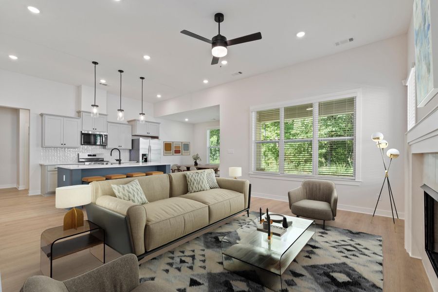 Vaulted ceiling with recessed lighting, large windows, wood-finish flooring, built-in fireplace, and kitchen island with pendant lighting