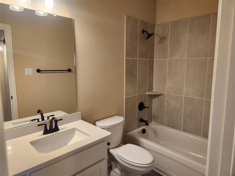 Full bathroom with vanity, toilet, and tiled shower / bath