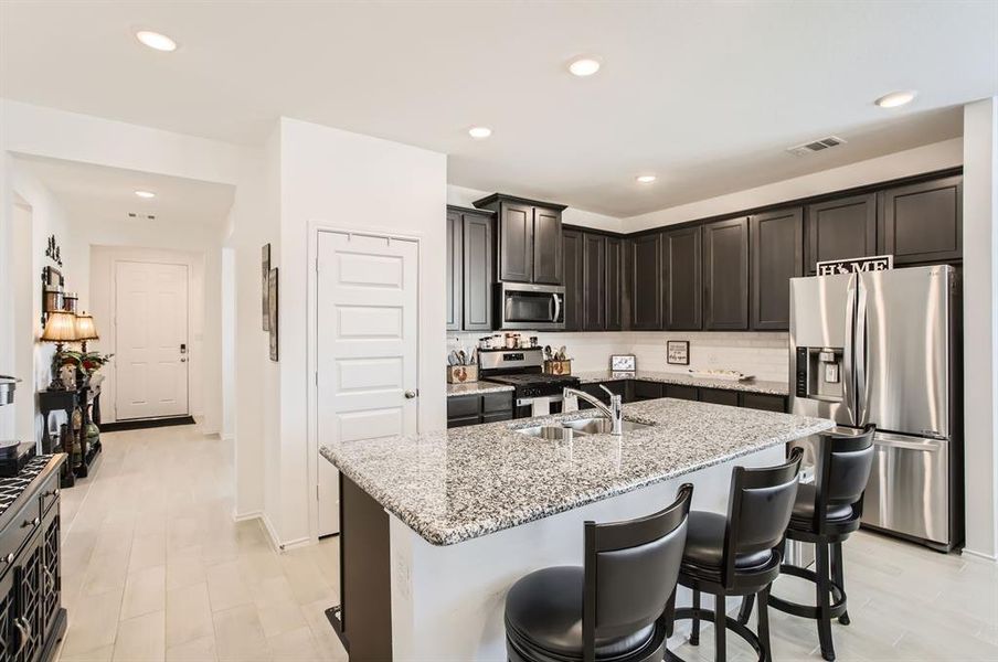 The kitchen has granite countertops, dark, rich cabinetry and stainless steel appliances.