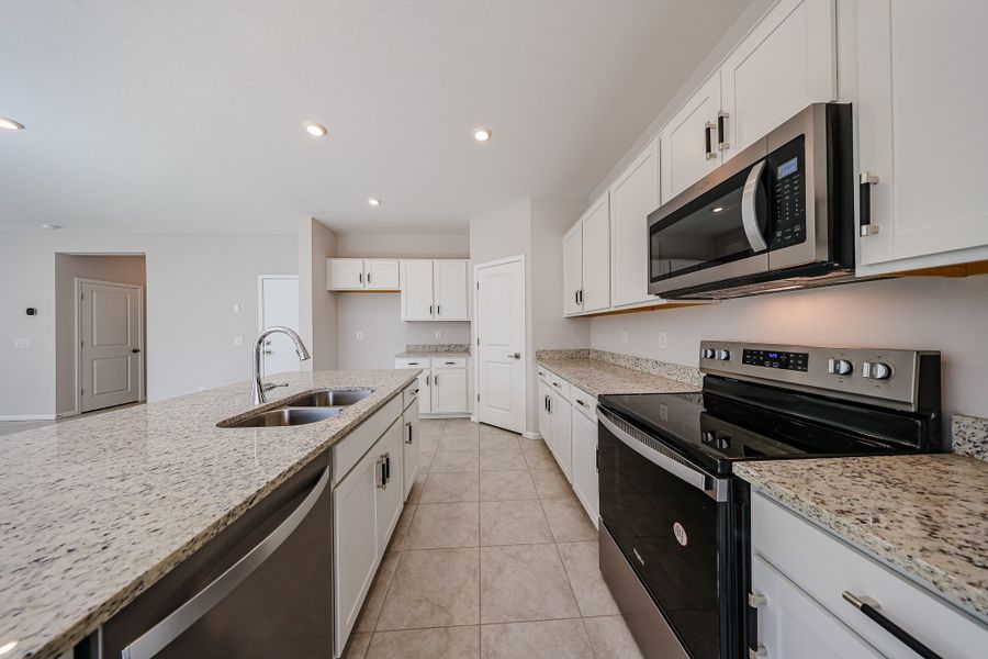 A kitchen with white cabinets.