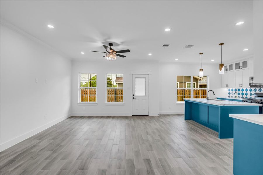 Bright and spacious, this modern living room flows seamlessly into an open-concept kitchen, featuring sleek finishes and abundant natural light, perfect for both relaxation and entertaining.