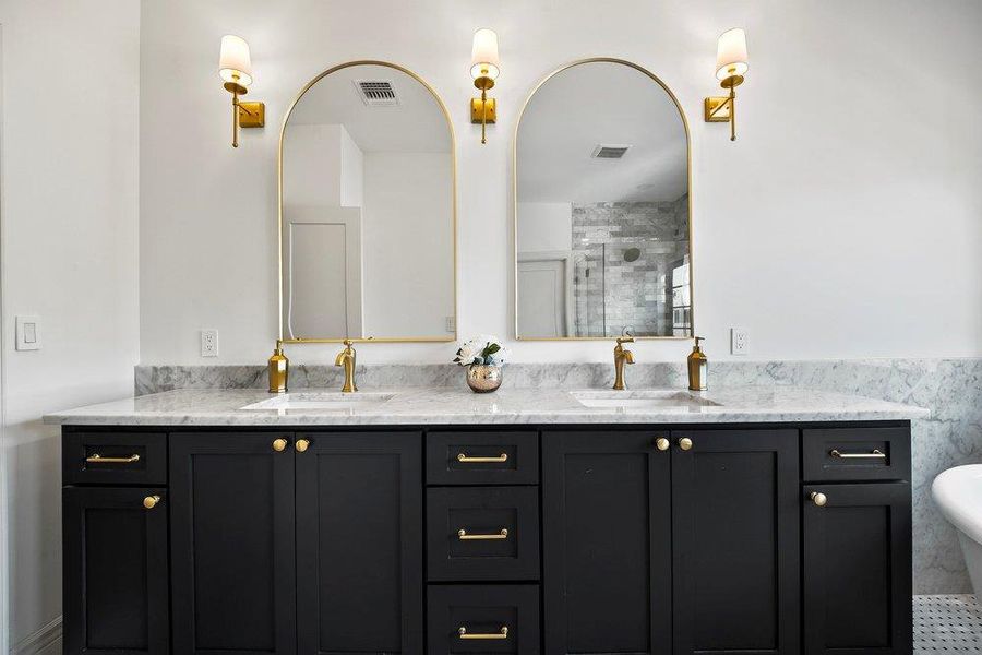 Full bathroom featuring double vanity, a freestanding bath, and a shower stall