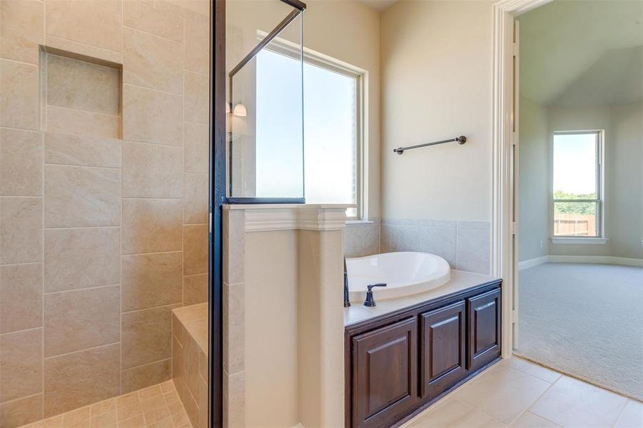 Bathroom featuring tile patterned flooring and separate shower and tub