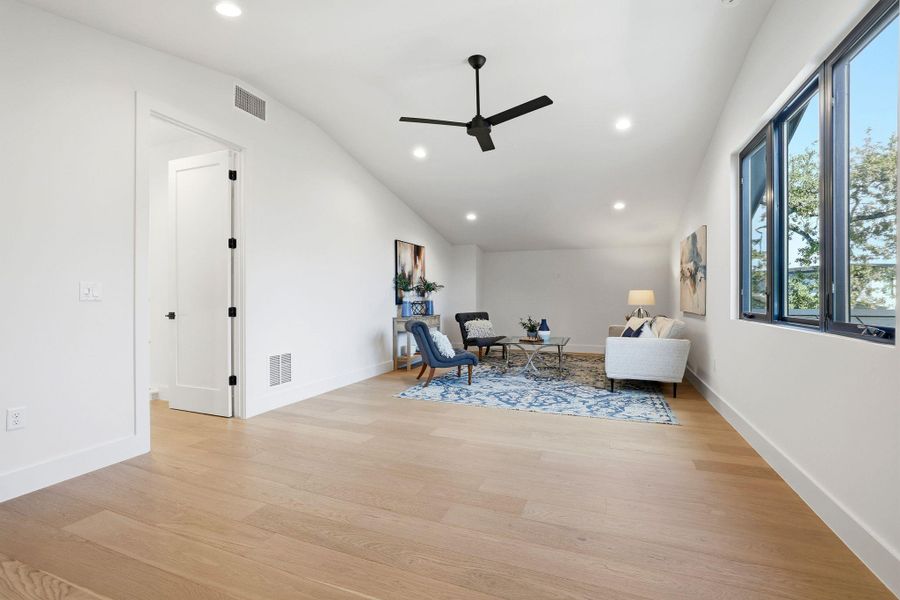 Living area featuring ceiling fan, light wood finished floors, recessed lighting, and vaulted ceiling