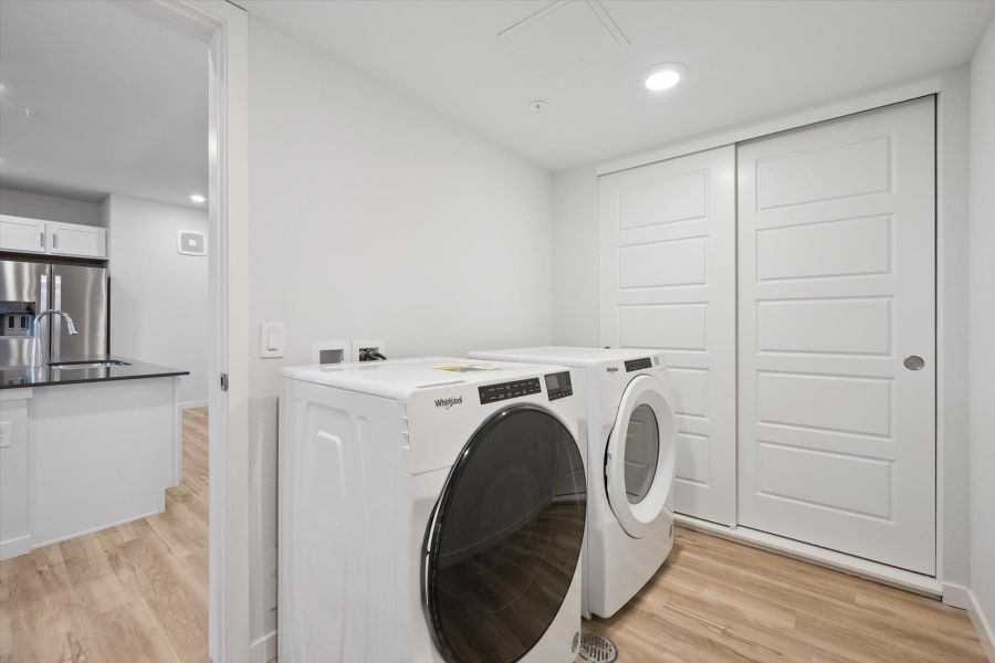 A white laundry room with a washer and dryer. A white laundry room with a washer and dryer.
