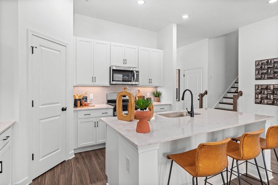 A kitchen with white cabinets.