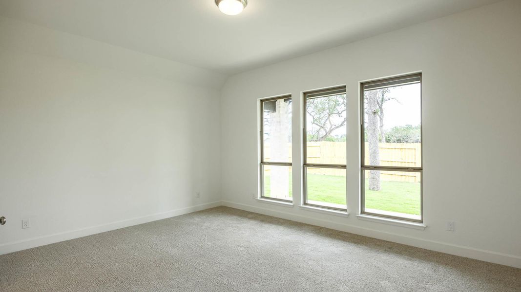 Spare room featuring carpet floors and lofted ceiling