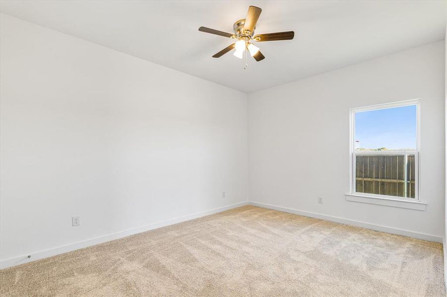 Empty room with light carpet and ceiling fan Empty room with light carpet and ceiling fan