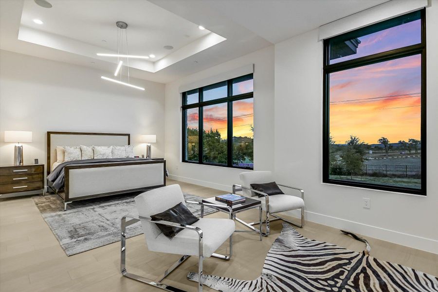 Bedroom featuring a tray ceiling and light wood-type flooring Bedroom featuring a tray ceiling and light wood-type flooring