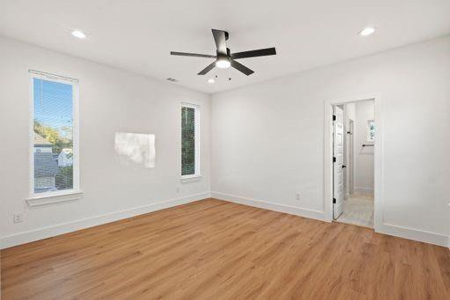 Empty room with light hardwood / wood-style floors and ceiling fan