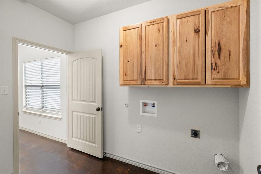 Clothes washing area featuring electric dryer hookup, gas dryer hookup, cabinets, and hookup for a washing machine