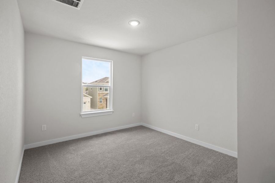 A room with a window and carpet.