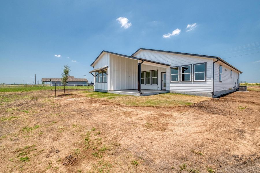 Rear view of house featuring central air condition unit, a patio area, and board and batten siding