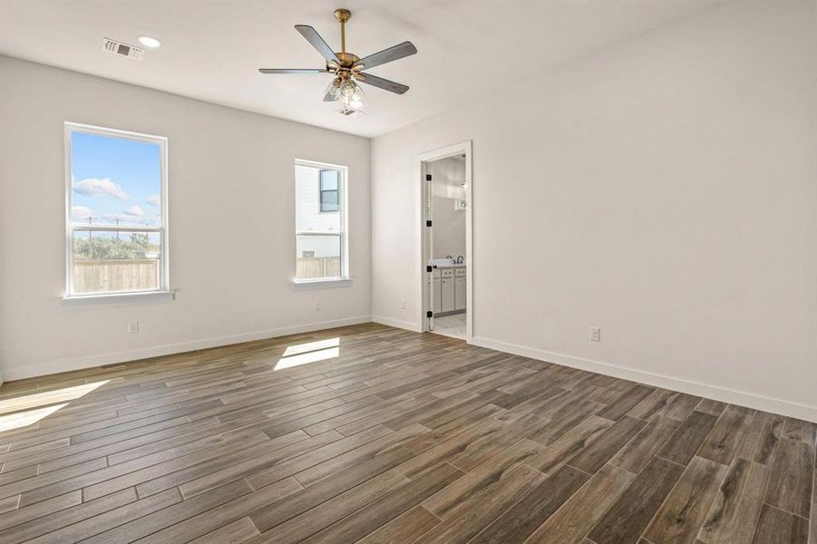 Spare room featuring dark wood-style floors, plenty of natural light, and baseboards