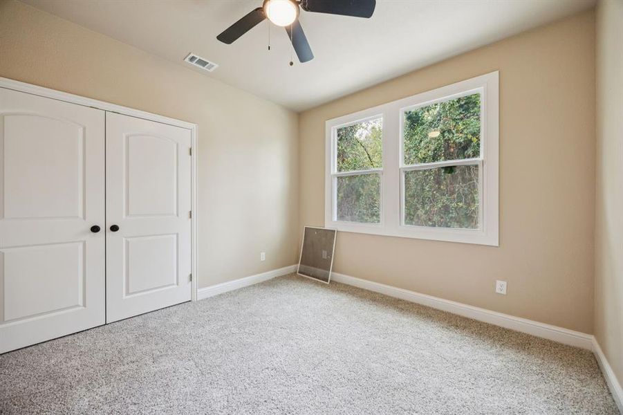 Unfurnished bedroom with carpet floors, a closet, and a ceiling fan Unfurnished bedroom with carpet floors, a closet, and a ceiling fan
