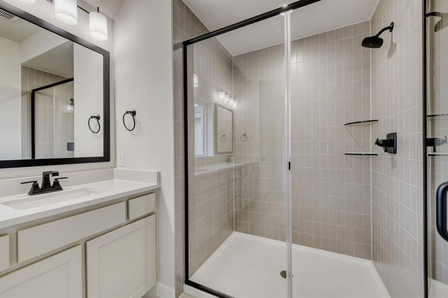 Contemporary bathroom featuring a walk-in shower with light gray tile surround and glass enclosure
