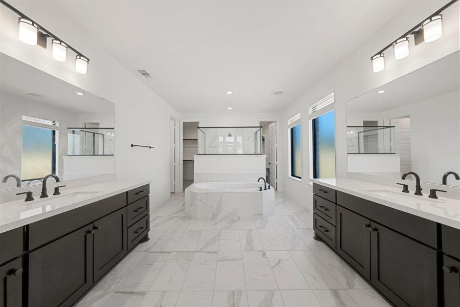 Full bath with marble finish floor, walk in shower, a garden tub, and a sink