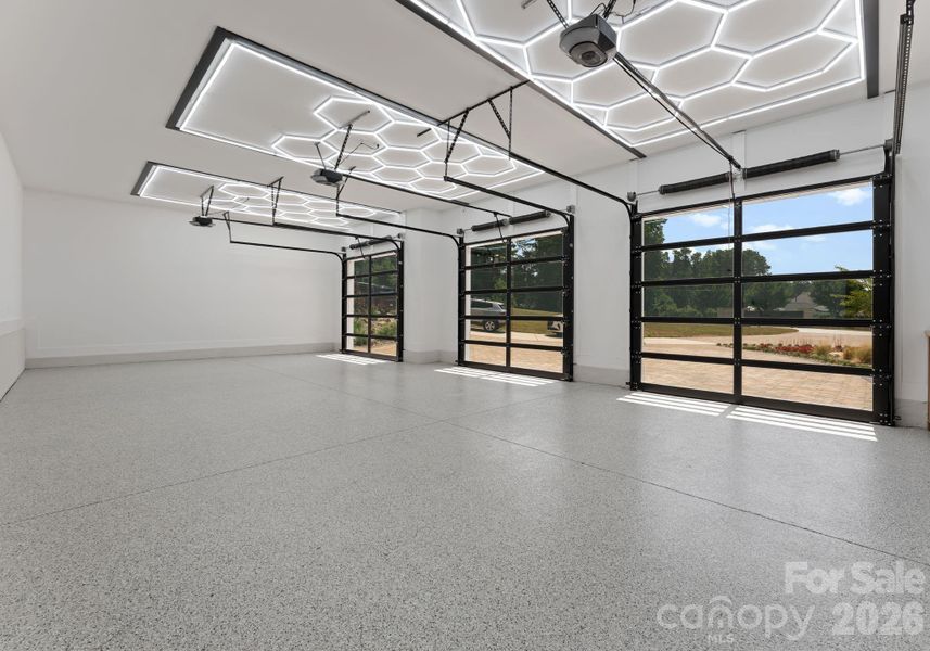 Garage with glass-paneled doors featuring additional built-in cabinetry and storage. Garage with glass-paneled doors featuring additional built-in cabinetry and storage.