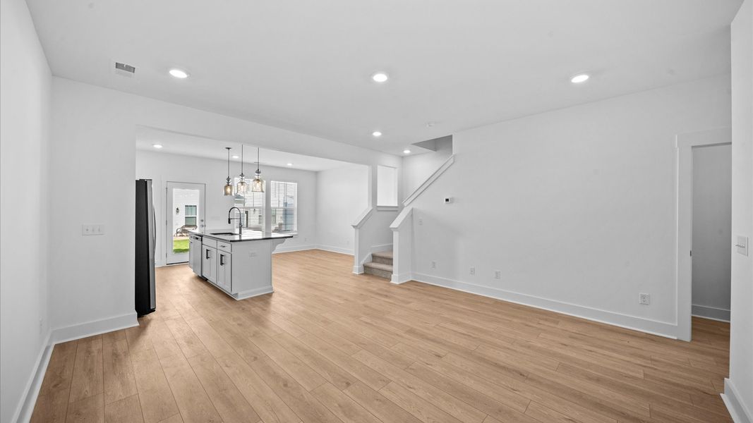 Spacious family room with rich hardwood flooring and elegant trim work in a reputable DRB Homes build Spacious family room with rich hardwood flooring and elegant trim work in a reputable DRB Homes build