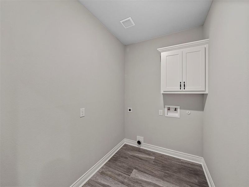 Laundry area featuring electric dryer hookup, dark wood finished floors, cabinet space, and washer hookup Laundry area featuring electric dryer hookup, dark wood finished floors, cabinet space, and washer hookup