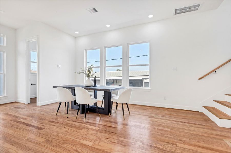 Another view of the dining area, featuring a convenient half bath tucked away in the corner for added functionality. (Representation of previously built homes. Actual colors and finishes will vary.) Another view of the dining area, featuring a convenient half bath tucked away in the corner for added functionality. (Representation of previously built homes. Actual colors and finishes will vary.)