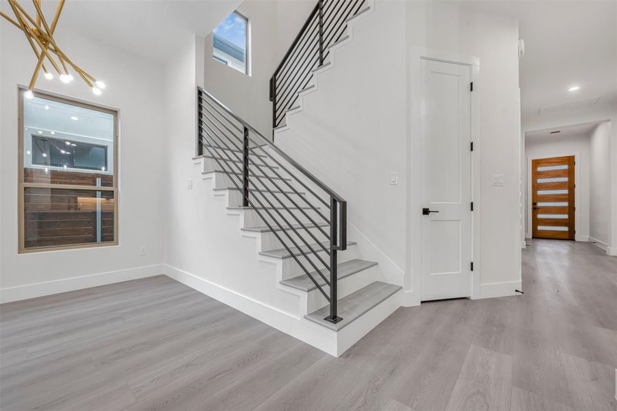 Staircase featuring wood-finished flooring, recessed lighting, and detailed baseboards. Staircase featuring wood-finished flooring, recessed lighting, and detailed baseboards.