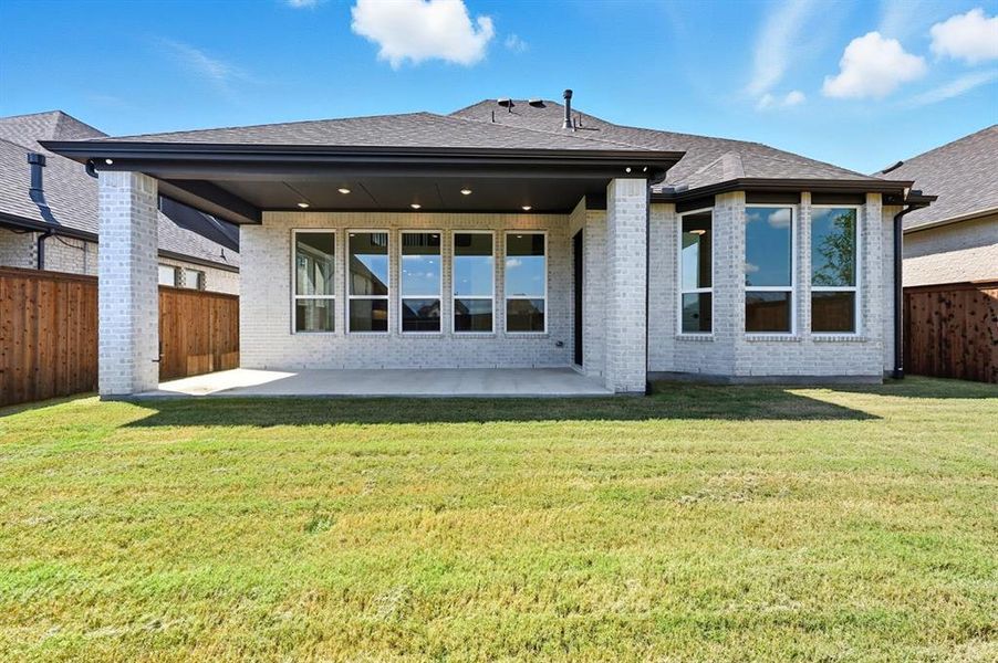 Back of house featuring a fenced backyard, a patio, brick siding, and a shingled roof Back of house featuring a fenced backyard, a patio, brick siding, and a shingled roof