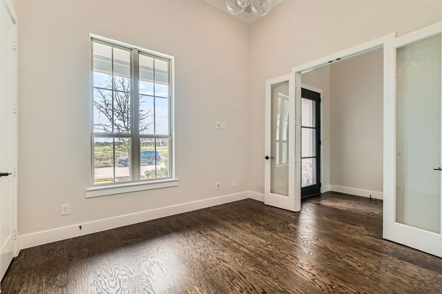 Empty room featuring french doors and dark wood-type flooring Empty room featuring french doors and dark wood-type flooring