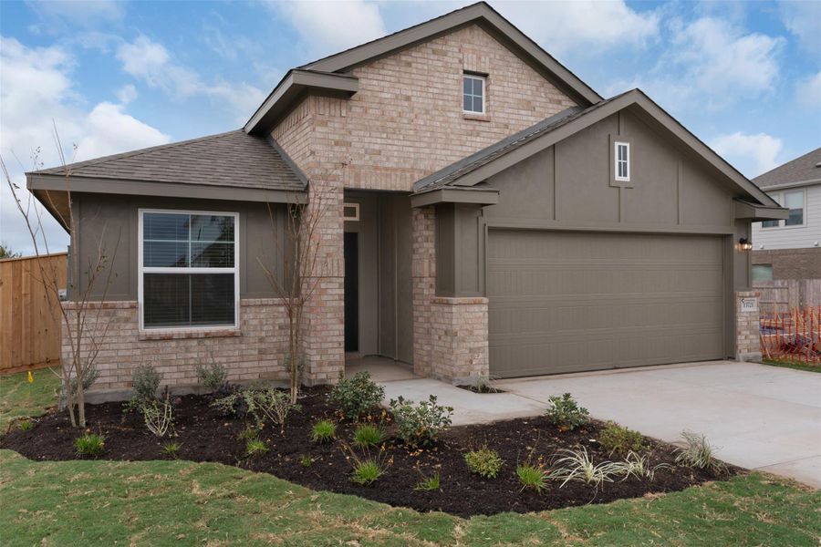 View of front of house featuring driveway, roof with shingles, and brick siding